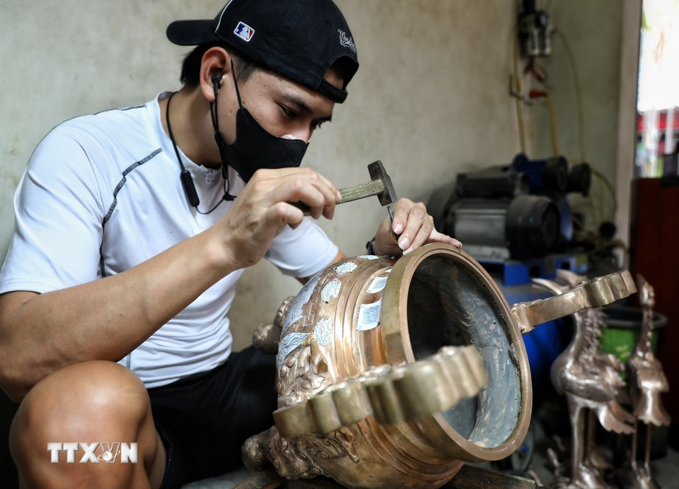 Nghề gò, đúc đồng đòi hỏi thao tác rất tỉ mỉ. (Ảnh: Danh Lam/TTXVN)