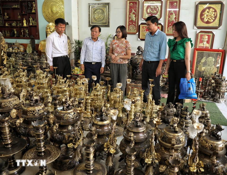 Khách đến tham quan, mua hàng tại các gian trưng bày tại làng nghề. (Ảnh: Danh Lam/TTXVN)