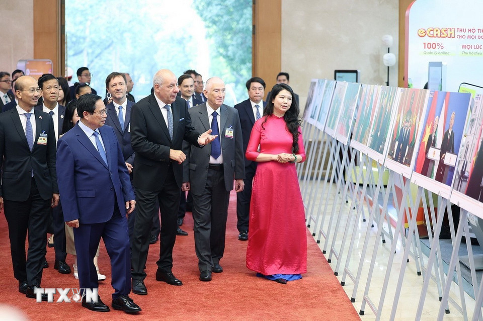 Thủ tướng Phạm Minh Chính và Tổng thống Hungary Sulyok Tamas tham quan trưng bày ảnh về hợp tác giữa hai nước, do Thông tấn xã Việt Nam thực hiện. (Ảnh: Dương Giang/TTXVN)