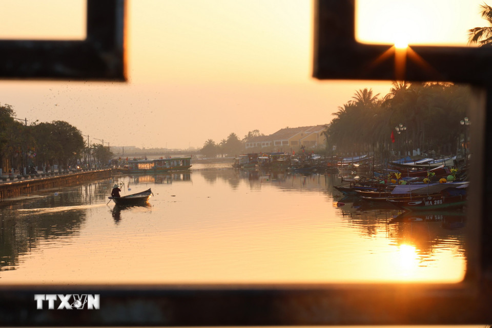 Một người dân dùng thuyền nhỏ đi thả lưới vào buổi sáng sớm trên dòng sông Hoài. (Ảnh: Xuân Quý/TTXVN)