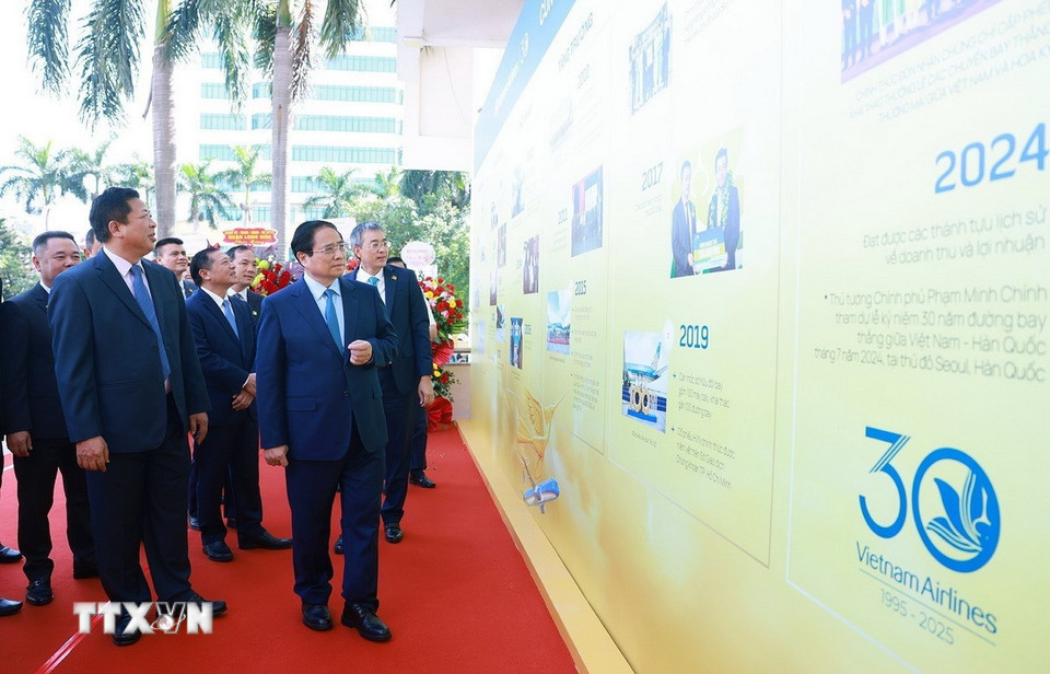 Thủ tướng Phạm Minh Chính tham quan trưng bày ảnh 30 năm thành lập Tổng Công ty Hàng không Việt Nam. (Ảnh: Dương Giang/TTXVN)