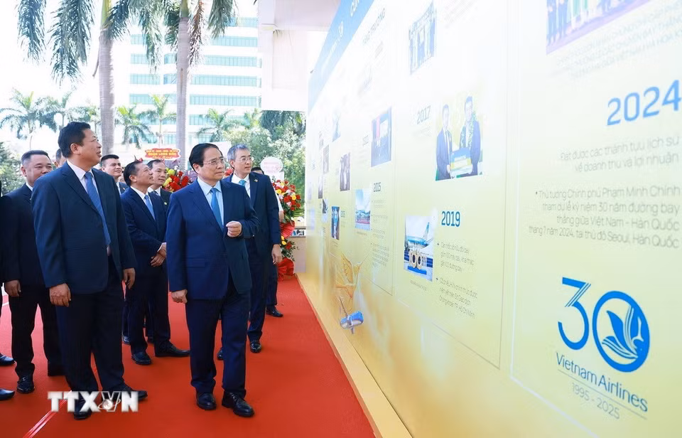 Thủ tướng Phạm Minh Chính tham quan trưng bày ảnh 30 năm thành lập Tổng Công ty Hàng không Việt Nam. (Ảnh: Dương Giang/TTXVN)
