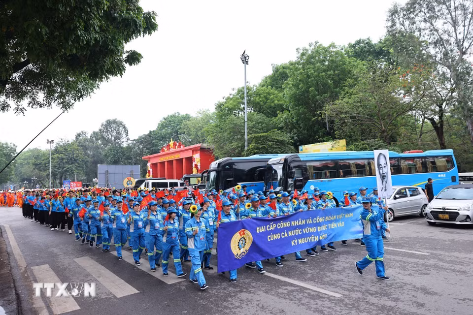 Công nhân lao động diễu hành chào mừng kỷ niệm 140 năm Ngày Quốc tế Lao động. (Ảnh: Minh Đức/TTXVN)