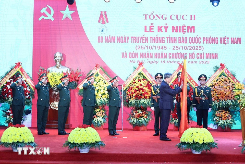 Tổng Bí thư Tô Lâm gắn Huân chương Hồ Chí Minh lên lá cờ truyền thống lực lượng Tình báo Quốc phòng Việt Nam. (Ảnh: Thống Nhất/TTXVN)
