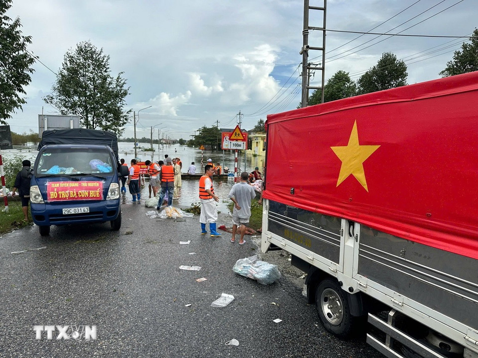 Các đoàn tình nguyện vận chuyển hàng hóa lên ghe để đưa vào những vùng ngập sâu ở thành phố Huế. (Ảnh: Đỗ Trưởng/TTXVN)