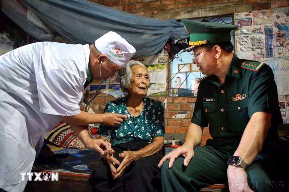 Cụ Đặng Thị Thang (84 tuổi, ngụ ấp Tân Hoà, xã Tân Lập) bày tỏ niềm vui với Đại tá Phạm Đình Triệu, Chính uỷ Bộ đội Biên phòng tỉnh Tây Ninh khi đến nhà thăm hỏi ngày Tết. (Ảnh: Giang Phương/TTXVN)