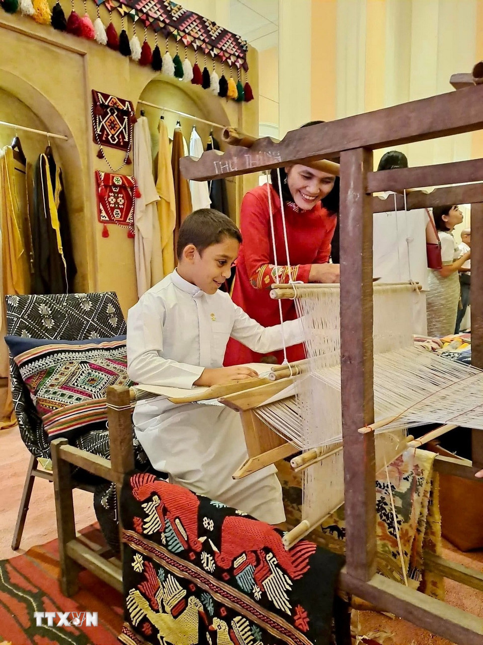 Du khách quốc tế trải nghiệm dệt thổ cẩm. (Ảnh: TTXVN phát)