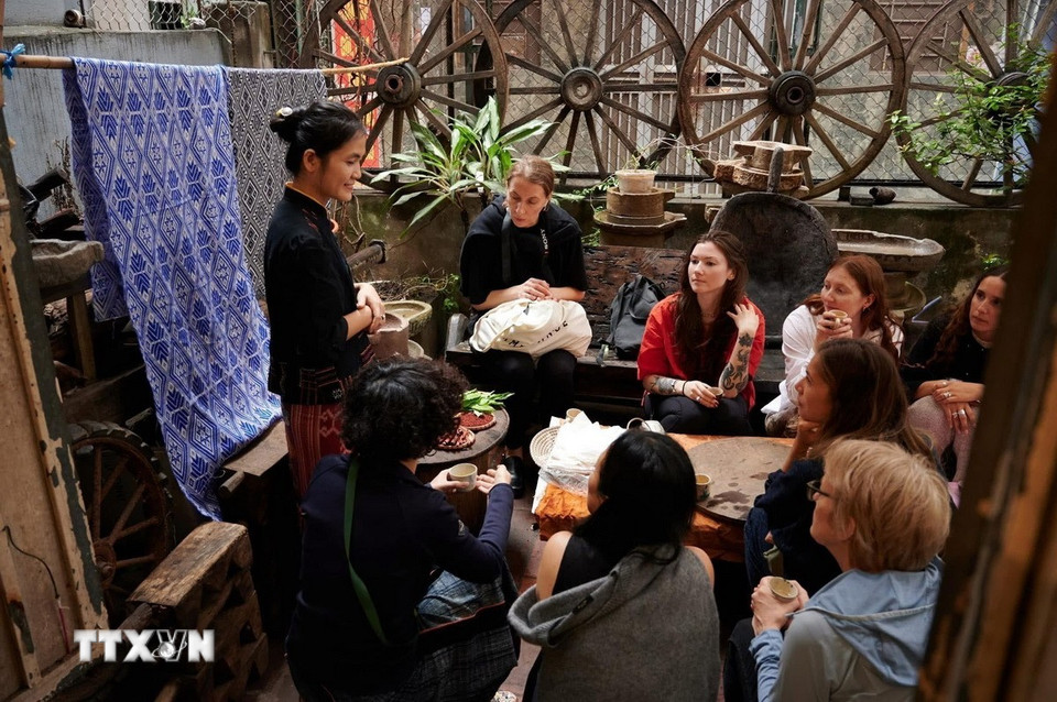 Du khách tìm hiểu về nghề dệt thổ cẩm của người Thái ở Nghệ An. (Ảnh: TTXVN phát)