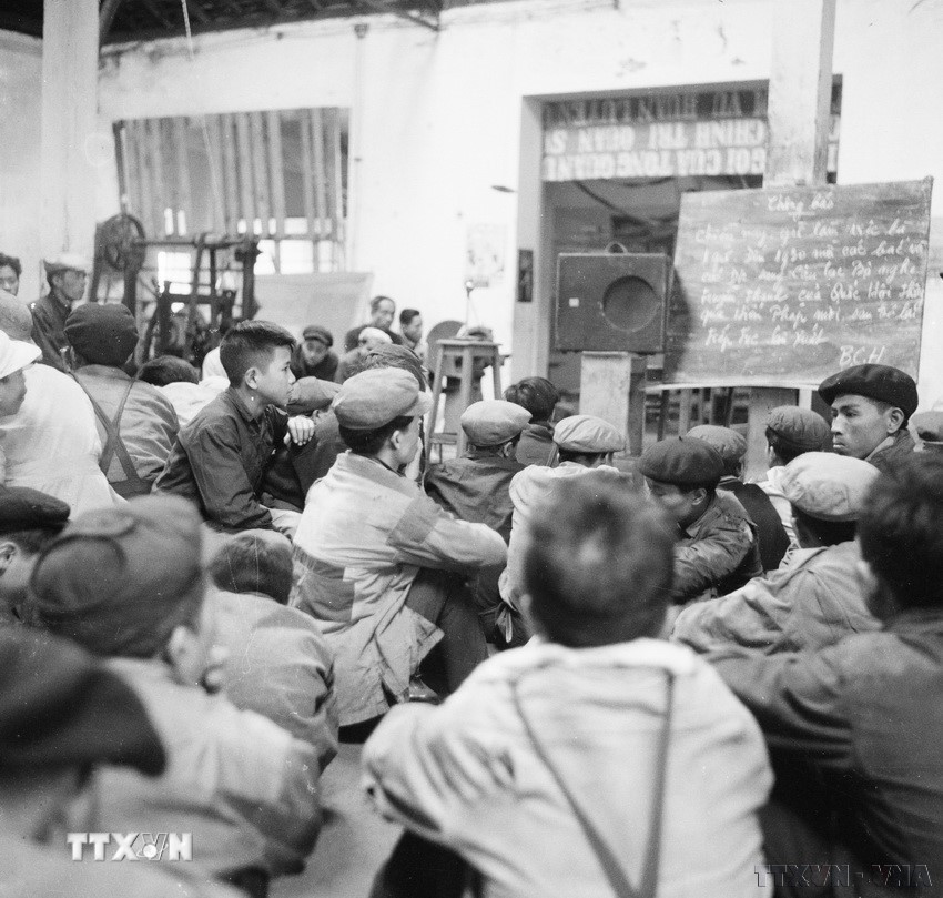 Công nhân công xưởng "công tư hợp doanh" Tự Lực nghe tường thuật qua đài phát thanh về cuộc họp thông qua quyết nghị của Quốc hội về Hiến pháp mới (1/1/1960). (Ảnh: TTXVN)