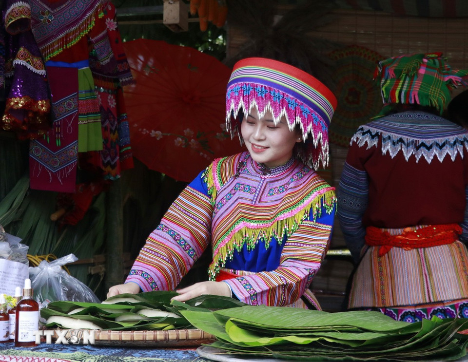 Thiếu nữ Mông bán bánh giầy - món ăn không thể thiếu của người Mông trong dịp lễ, Tết. (Ảnh: Đinh Thùy/TTXVN)