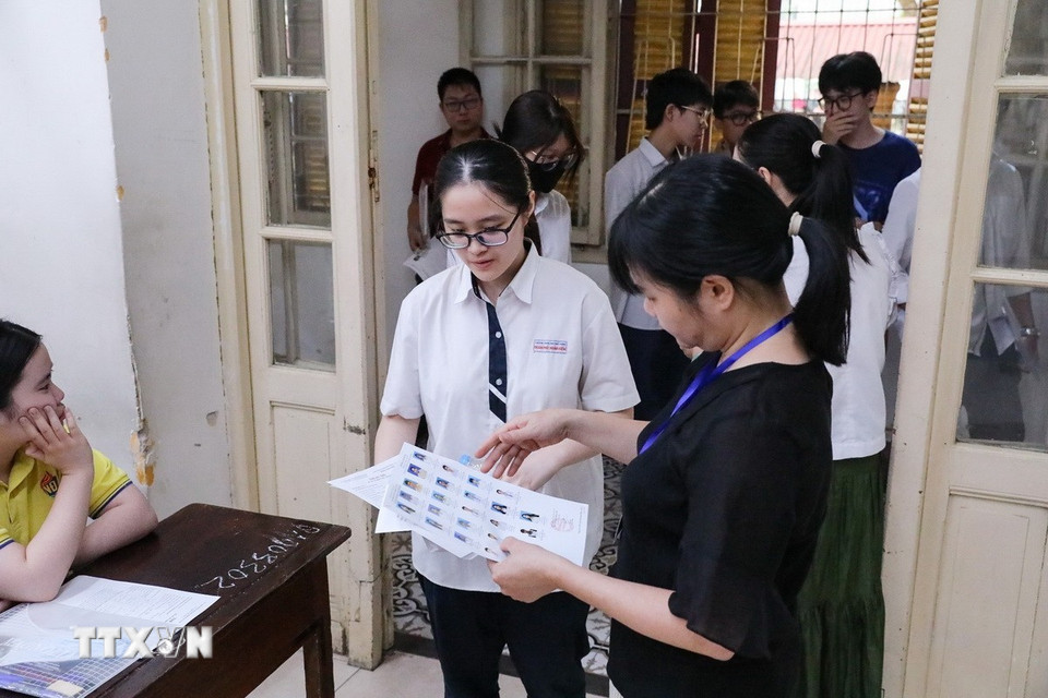 Kiểm tra thông tin thí sinh trước khi vào phòng thi tại điểm trường THPT Trần Phú quận Hoàn Kiếm, Hà Nội. (Ảnh: Khánh Hòa/TTXVN)