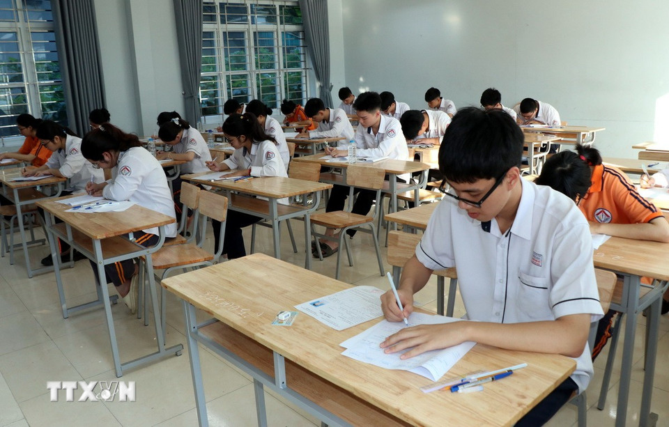 Các thí sinh ghi thông tin trên bài thi. (Ảnh: Nguyễn Lành/ TTXVN)