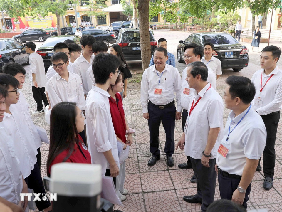 Bộ trưởng Bộ Giáo dục và Đào tạọ Nguyễn Kim Sơn (thứ 2 phải sang) hỏi thăm thí sinh thi tốt nghiệp trung học phổ thông tại Trường THPT Hài Bà Trưng, thành phố Phúc Yên. (Ảnh: Hoàng Hùng/TTXVN)