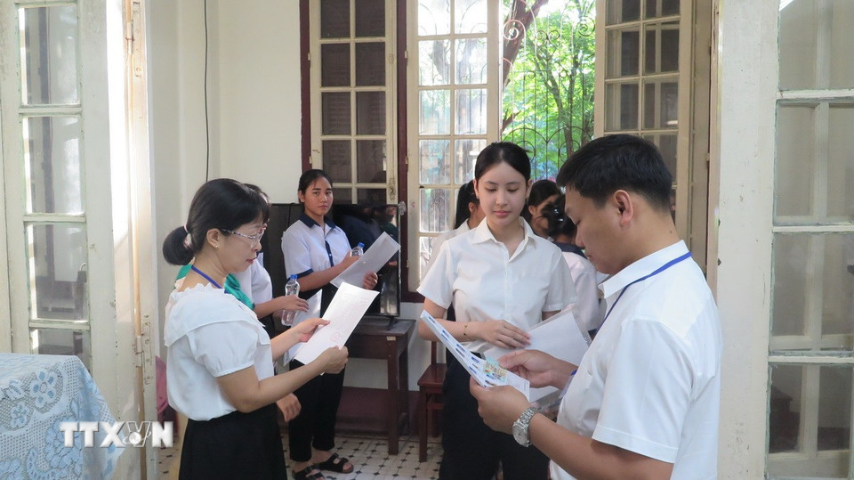 Giám thị gọi thí sinh vào phòng thi. (Ảnh: Tường Vi/ TTXVN)