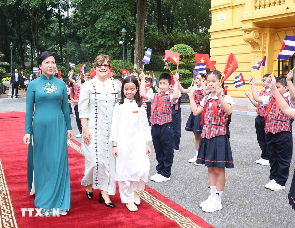 Phu nhân Ngô Phương Ly và Phu nhân Lis Cuesta Peraza với thiếu nhi Hà Nội tại lễ đón. (Ảnh: Thống Nhất/ TTXVN)