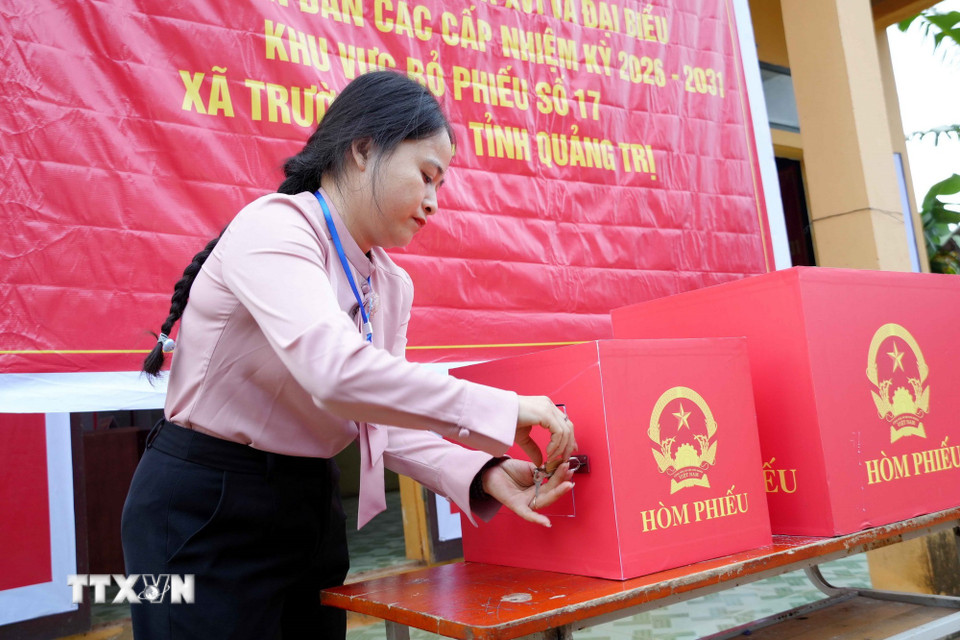 Bà Trần Thị Dung, Tổ trưởng Khu vực bỏ phiếu số 17, bản Nước Đắng, xã Trường Sơn (Quảng Trị) thực hiện việc niêm phong thùng phiếu. (Ảnh: Tá Chuyên/TTXVN)