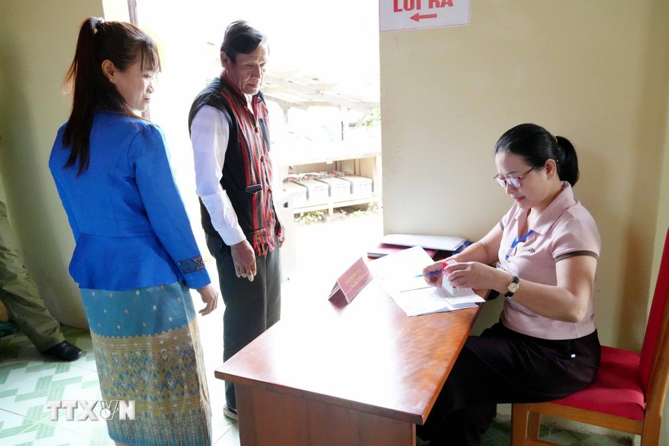 Đóng dấu xác nhận cử tri bản Nước Đắng (xã Trường Sơn, Quảng Ninh) đã hoàn thành việc bỏ phiếu bầu đại biểu Quốc hội khóa XVI và đại biểu Hội đồng nhân dân các cấp nhiệm kỳ 2026-2031. (Ảnh: Tá Chuyên/TTXVN)