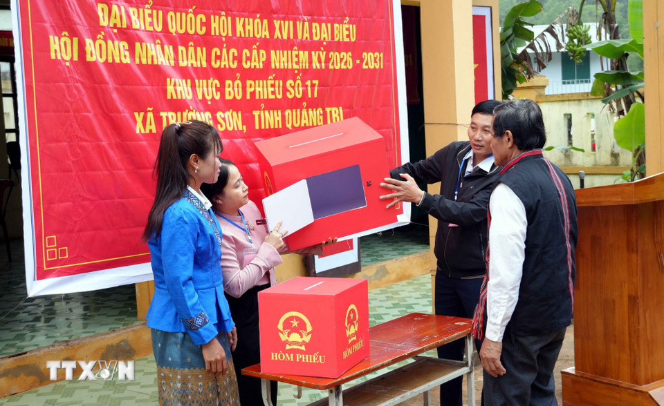 Cử tri kiểm tra, xác nhận thùng phiếu trống trước khi bỏ phiếu tại Khu vực bỏ phiếu số 17, bản Nước Đắng, xã Trường Sơn (Quảng Trị). (Ảnh: Tá Chuyên/TTXVN)