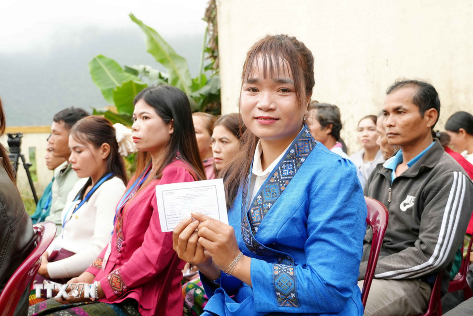 Em Hồ Thị Thiều, bản Nước Đắng, xã Trường Sơn (Quảng Trị) hân hoan cầm thẻ cử tri trong lần đầu tiên đi bỏ phiếu. (Ảnh: Tá Chuyên/TTXVN)