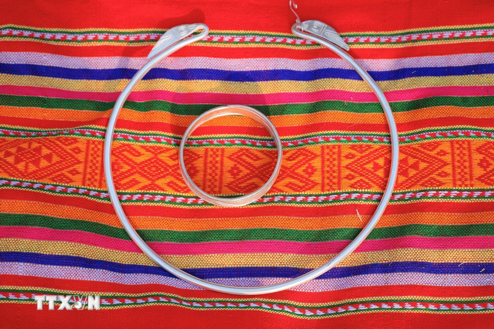 Bộ đồ bằng bạc, đặt trên vải thổ cẩm là vật không thể thiếu trong lễ cúng mừng cơm mới. (Ảnh: Hoàng Hiếu/ TTXVN)