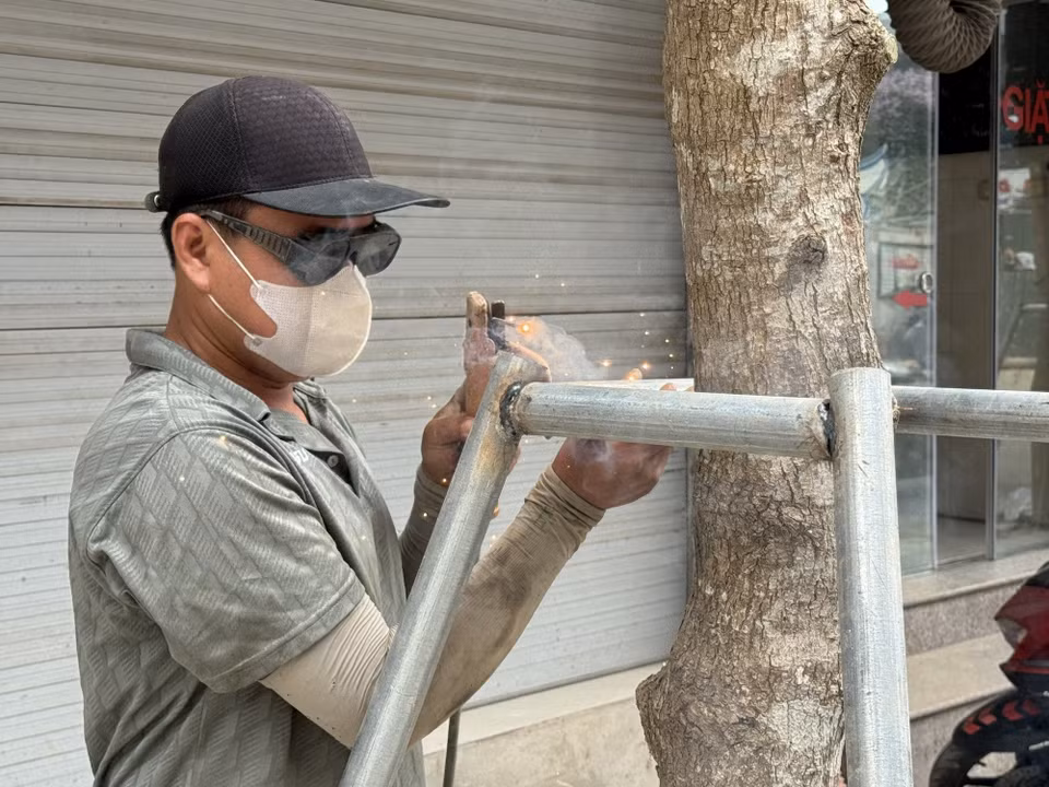 Người lao động phải làm việc ngoài trời dưới nền nhiệt gần 40 độ C. (Ảnh: Quốc Lũy/ TTXVN)