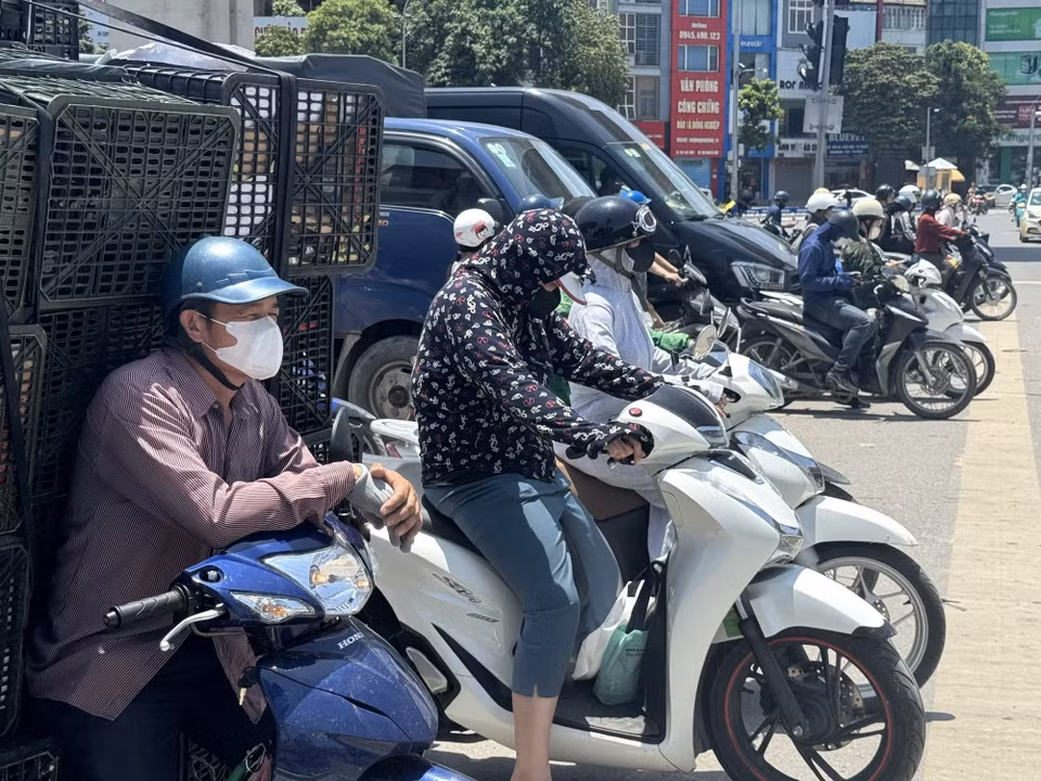 Trên các tuyến đường, người tham gia giao thông vất vả di chuyển dưới hơi nóng hầm hập phả lên từ mặt đường. (Ảnh: Quốc Lũy/TTXVN)