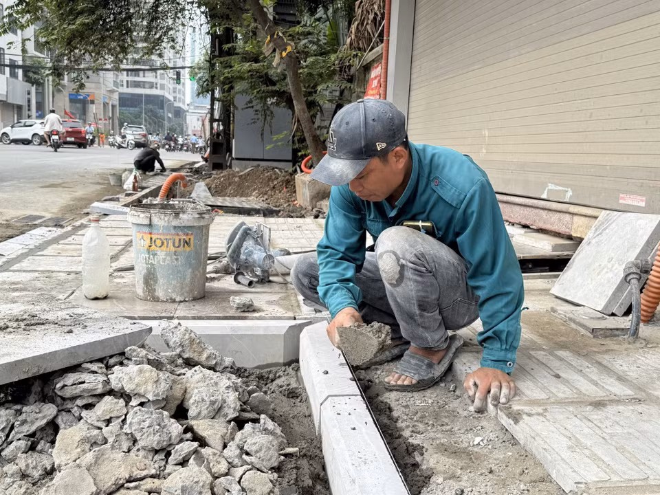Người lao động phải làm việc ngoài trời dưới nền nhiệt gần 40 độ C. (Ảnh: Quốc Lũy/ TTXVN)
