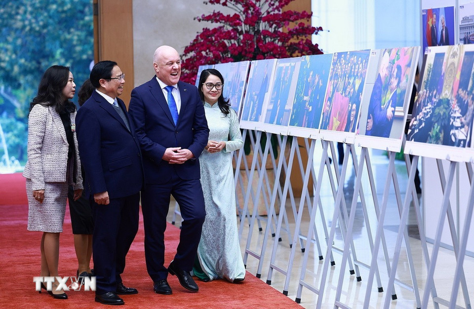 Thủ tướng Phạm Minh Chính và Thủ tướng New Zealand Christopher Luxon tham quan trưng bày ảnh về quan hệ hợp tác giữa hai nước. (Ảnh: Dương Giang/TTXVN)