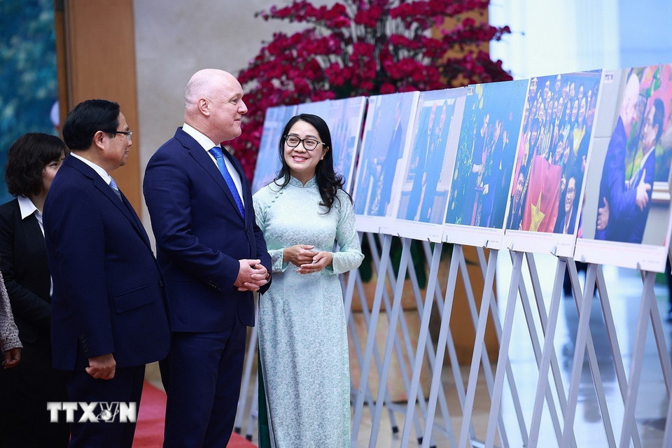 Thủ tướng Phạm Minh Chính và Thủ tướng New Zealand Christopher Luxon tham quan trưng bày ảnh về quan hệ hợp tác giữa hai nước. (Ảnh: Dương Giang/TTXVN)