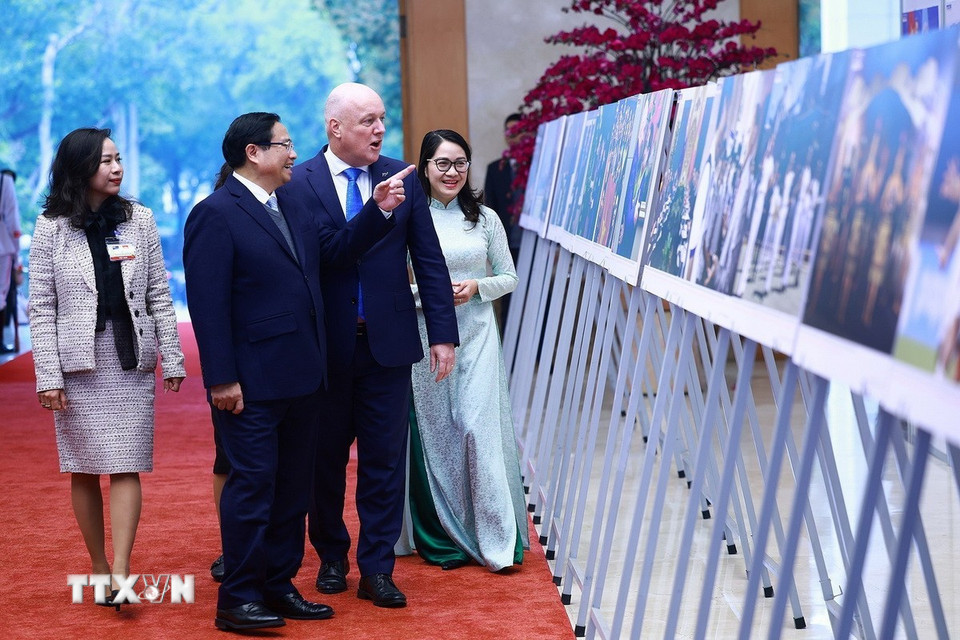 Thủ tướng Phạm Minh Chính và Thủ tướng New Zealand Christopher Luxon tham quan trưng bày ảnh về quan hệ hợp tác giữa hai nước. (Ảnh: Dương Giang/TTXVN)