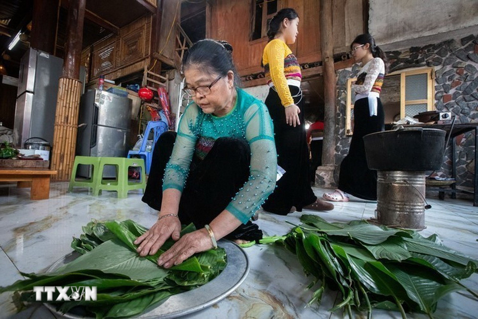 Bà Hà Thị Ứn tại bản Pom Coọng (Mai Châu, Phú Thọ) chuẩn bị lá dong để gói xôi cho buổi lễ. (Ảnh: Trọng Đạt/ TTXVN)