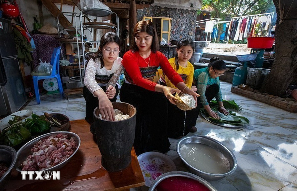 Khi lúa bắt đầu vào độ chín vàng, người phụ nữ Thái sẽ chọn những bông lúa đẹp nhất ở thửa ruộng tốt nhất, mang về treo gác bếp. Khi mùa màng gặt xong, họ mới đạp thóc, giã gạo, đồ xôi để làm lễ. (Ảnh: Trọng Đạt/TTXVN)