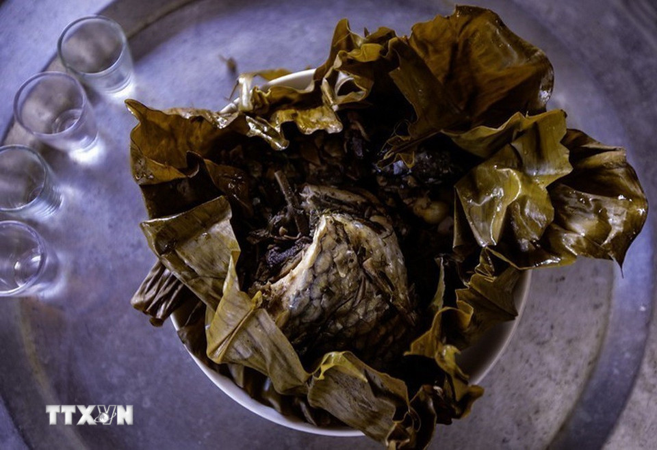 Cá hấp được gói trong lá dong, buộc lạt giang, hấp trong khoảng một giờ - món ăn đặc trưng của người Thái. (Ảnh: Trọng Đạt/TTXVN)
