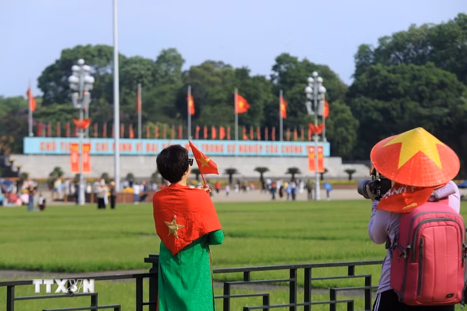 Người dân "check-in" với lá Quốc kỳ để thể hiện tinh thần yêu nước. (Ảnh: Tuấn Anh/TTXVN)