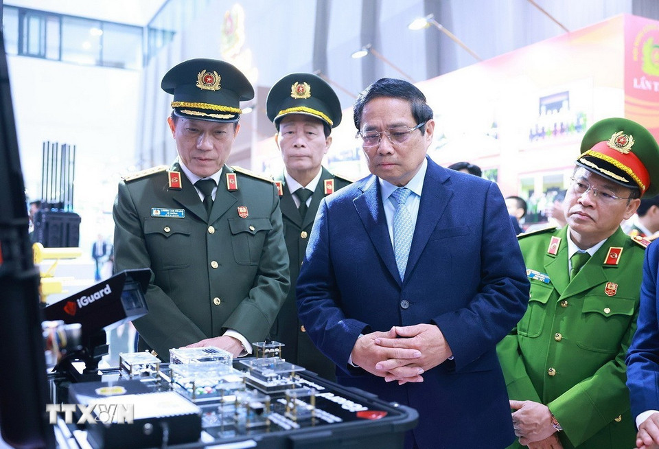 Thủ tướng Phạm Minh Chính tham quan sản phẩm ứng dụng công nghệ cao trưng bày tại Hội nghị Công an toàn quốc lần thứ 80. (Ảnh: Dương Giang/TTXVN)