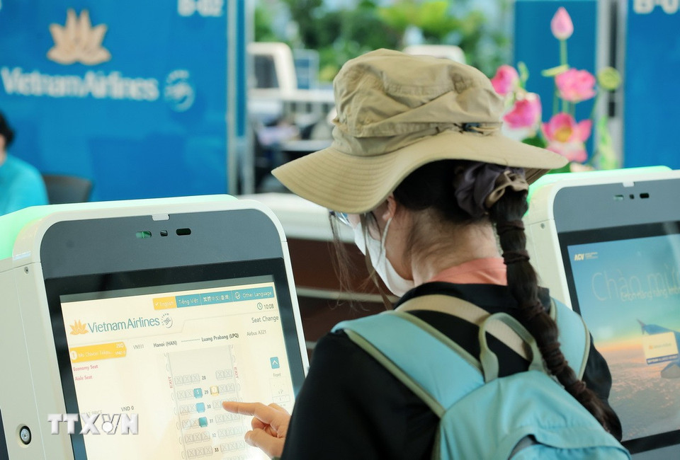 Du khách nước làm thủ tục check-in tự động để chọn chỗ ngồi và in thẻ lên tàu bay tại nhà ga T2 Nội Bài. (Ảnh: Quốc Khánh/TTXVN)