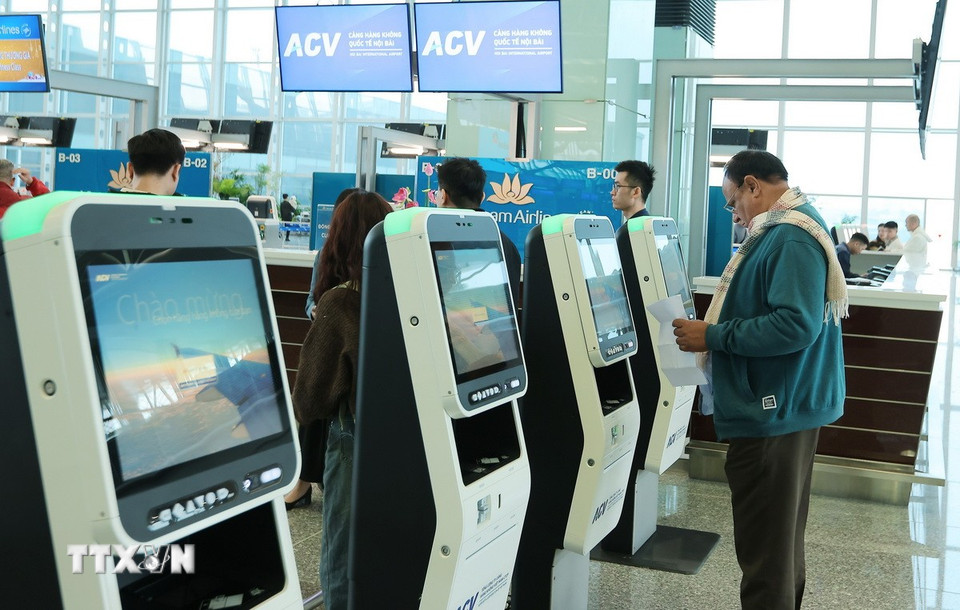 Du khách làm thủ tục check- in tự động chọn chỗ ngồi và in thẻ lên tàu bay. (Ảnh: Quốc Khánh/TTXVN)