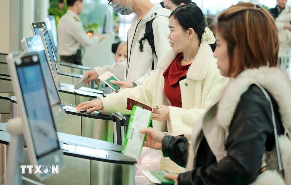 Hành khách sử dụng công nghệ quét QR thẻ lên máy bay tại cửa ra tàu bay. (Ảnh: Quốc Khánh/TTXVN)