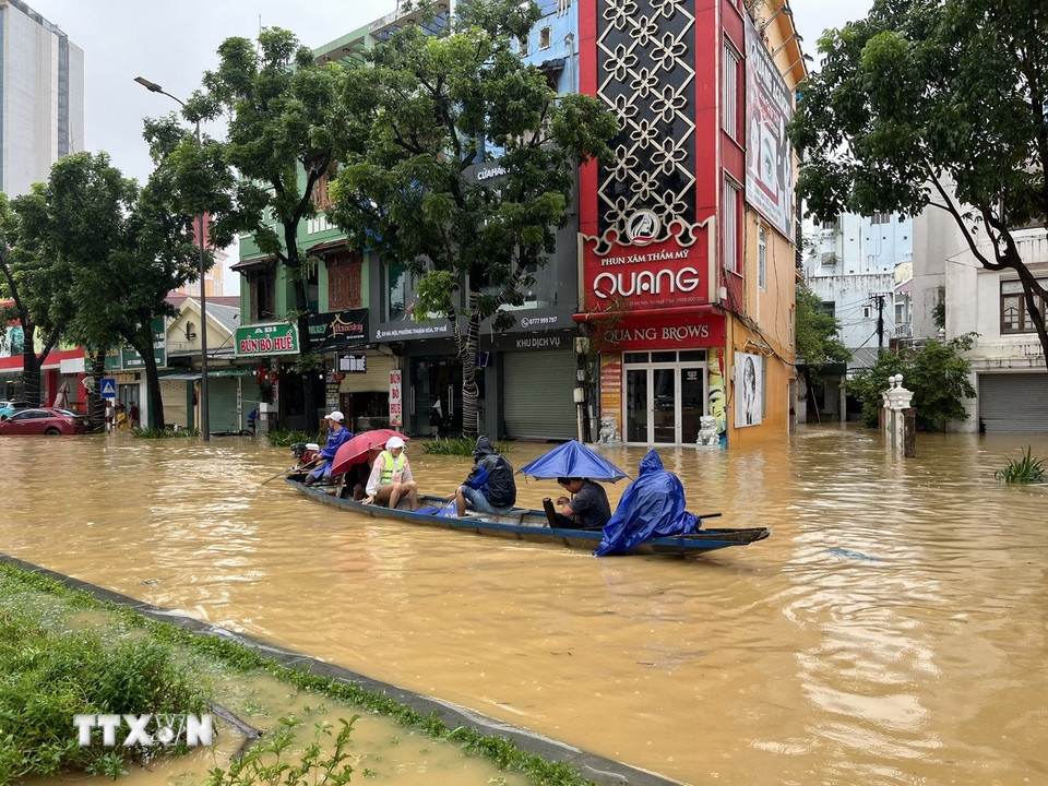 Người dân vẫn di chuyển bằng thuyền trên các tuyến đường chính ở trung tâm thành phố Huế. (Ảnh: Văn Dũng/TTXVN)