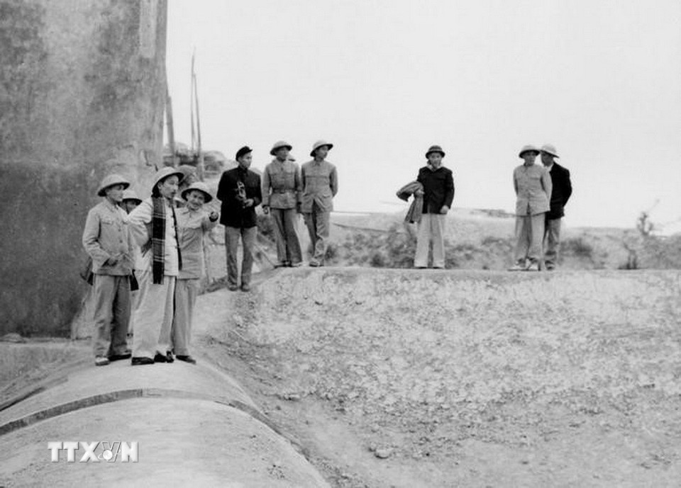 Phóng viên Võ Thế Ái của Việt Nam Thông tấn xã (đứng sau Bác Hồ) tháp tùng Bác trong chuyến thăm công trình đập Thác Huống (Thái Nguyên) để viết tin, bài (25/1/1955). (Ảnh: TTXVN)