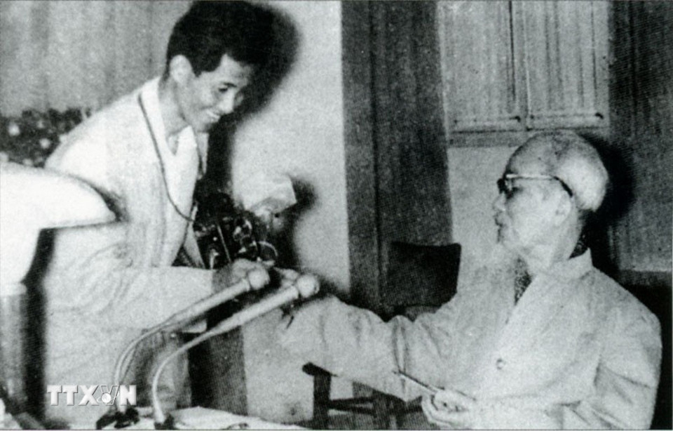 Chủ tịch Hồ Chí Minh tặng thuốc lá thơm cho nhà báo Lâm Hồng Long - tác giả của bức ảnh nổi tiếng "Bác bắt nhịp Bài ca Kết Đoàn." (Ảnh: Tư liệu TTXVN)