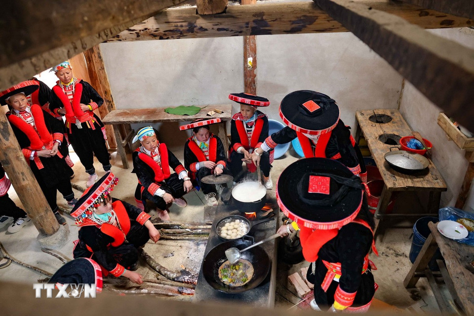 Bên bếp hồng, người phụ nữ Dao đỏ cùng nhóm lên ngọn lửa đoàn viên. (Ảnh: Thanh Tùng/TTXVN)