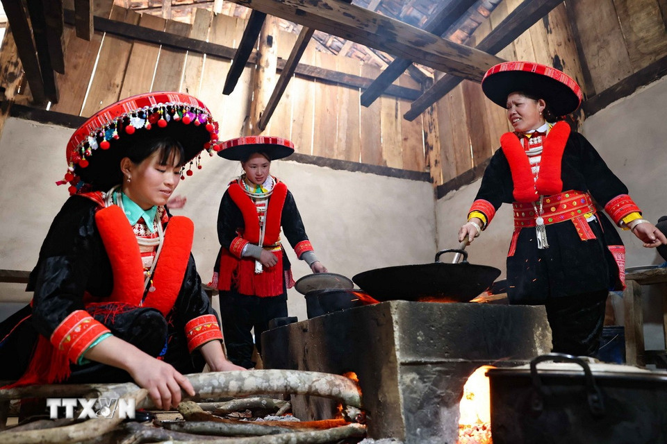 Bên bếp hồng, người phụ nữ Dao đỏ cùng nhóm lên ngọn lửa đoàn viên. (Ảnh: Thanh Tùng/TTXVN)