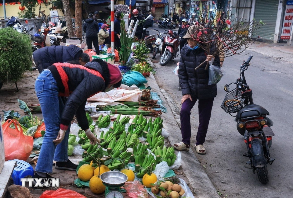 Người dân đi chợ lựa chọn những món đồ cho mâm Ngũ quả ngày Tết. (Ảnh: Tuấn Anh/TTXVN)