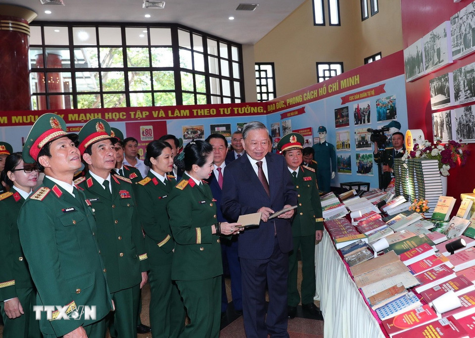 Tổng Bí thư Tô Lâm và các đại biểu tham quan Khu trưng bày ấn phẩm Quốc phòng. (Ảnh: Trọng Đức/TTXVN)