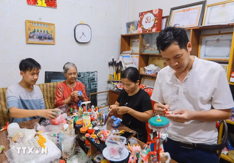 Gia đình ba thế hệ nhà nghệ nhân Đặng Văn Hậu tiếp truyền nghề truyền thống "Tò he". (Ảnh: Khánh Hòa/TTXVN)
