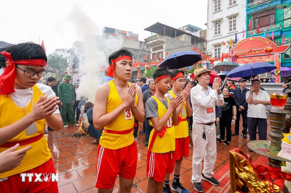 Các thiếu niên của 4 đội hoàn thành phần thi lấy nước mang về sân đình. (Ảnh: Khánh Hòa/TTXVN)