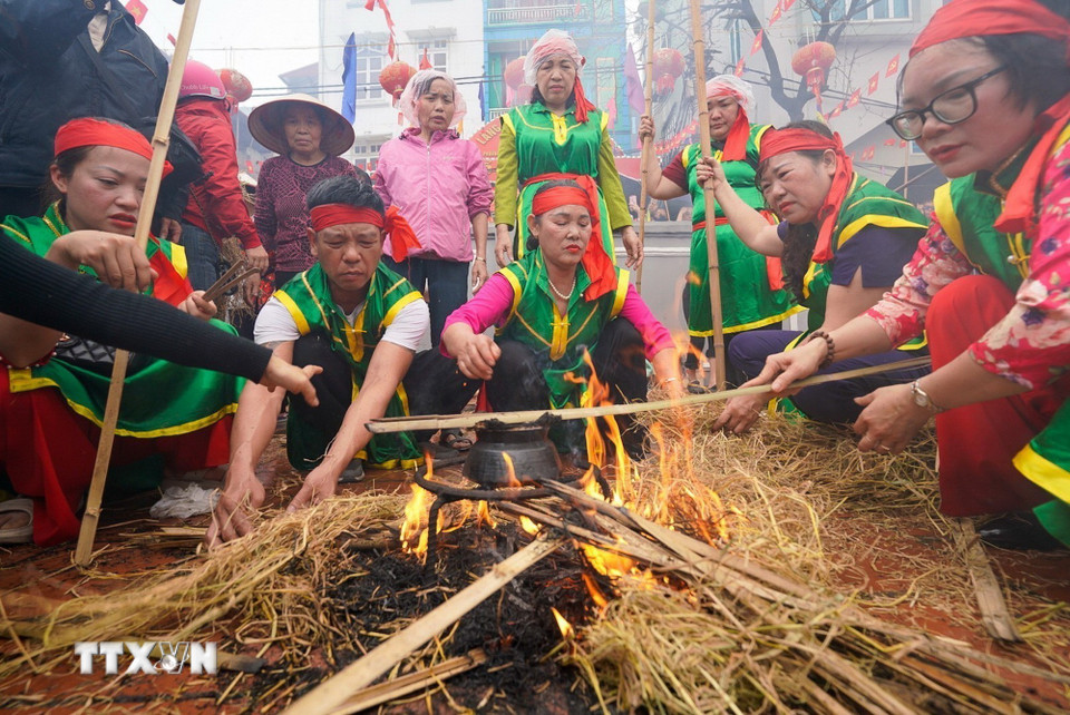 Phần thi thổi cơm của các đội thi diễn ra trong sân đình Thị Cấm. (Ảnh: Khánh Hòa/TTXVN)