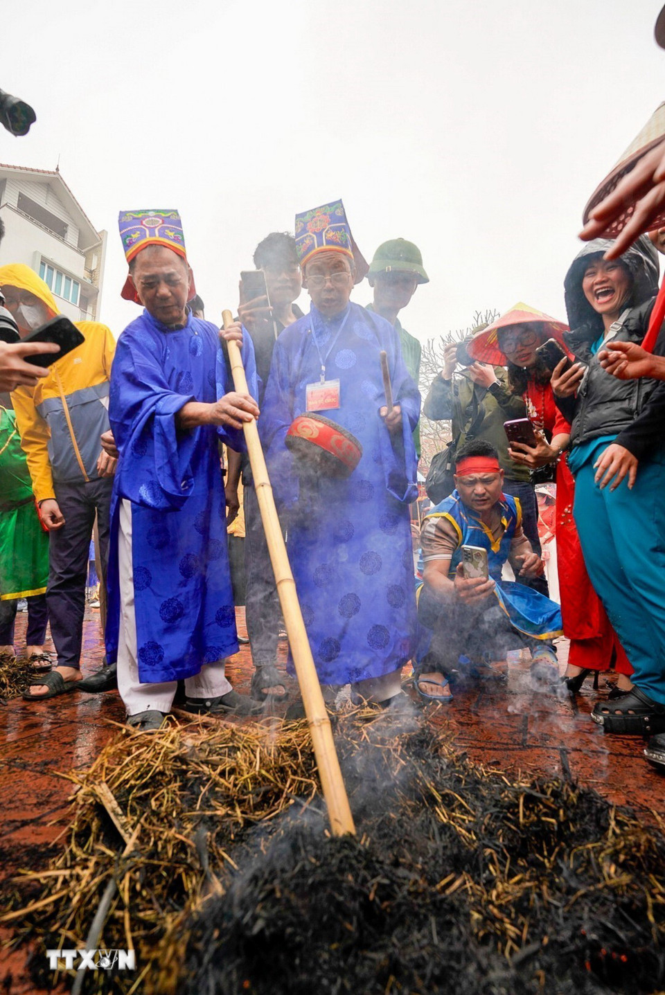 Ban giám khảo tìm nồi cơm giữa những đống tro, chuẩn bị cho phần chấm điểm công khai trước sự chứng kiến của đông đảo người dân. (Ảnh: Khánh Hòa/TTXVN)