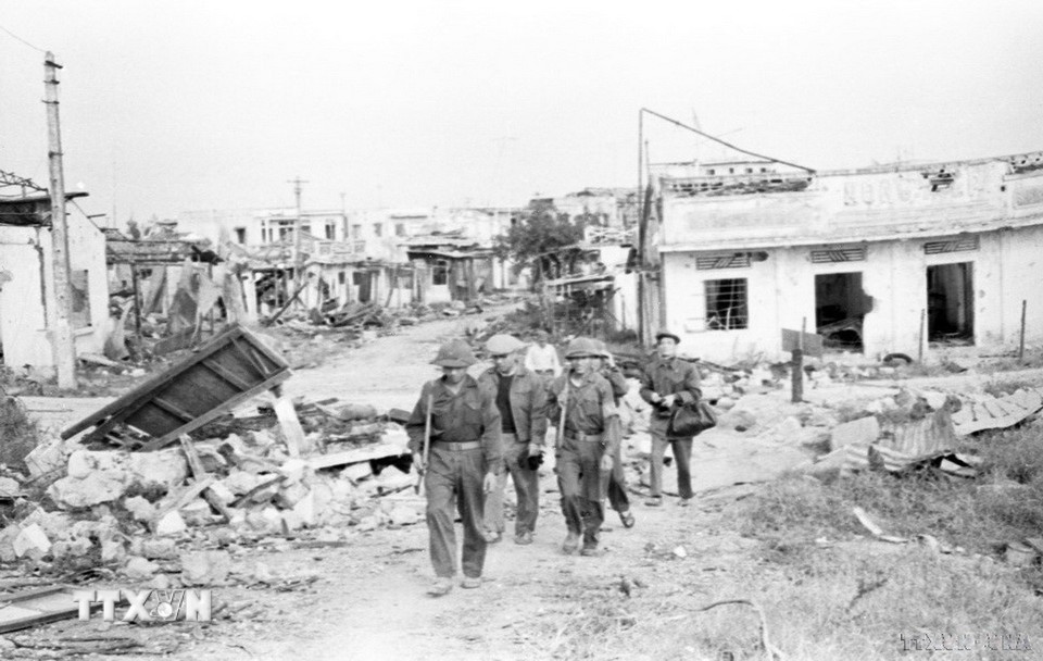 Trong công cuộc kháng chiến cứu quốc, phóng viên của TTXVN đã có mặt ở những địa bàn nóng bỏng, gian khổ nhất để ghi lại những hình ảnh chiến đấu dũng cảm, hào hùng của quân và dân ta. Trong ảnh: Phóng viên Việt Nam thông tấn xã trên đường Trần Hưng Đạo, Quảng Trị, năm 1972. (Ảnh: TTXVN)